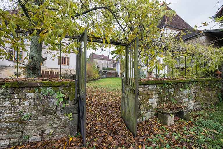 Le mur de clôture qui sépare le jardin d'agrément du jardin potager.