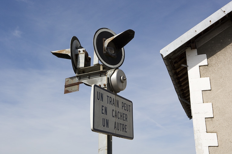 3 signaux lumineux, 2 panneaux de signalisation et 2 cloches (signaux sonores)